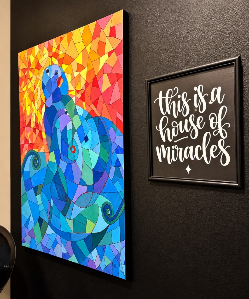 Artwork and a handwritten sign on the wall of the Beauty Sanctuary
